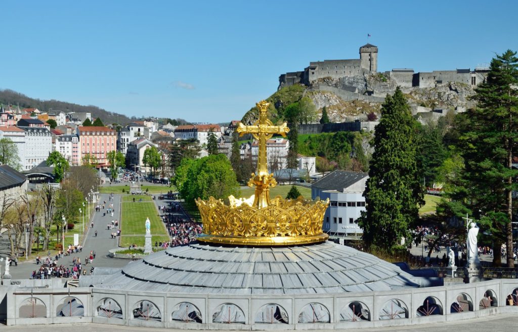 A golden cross in Lourdes, France during a tour with Portugal.com