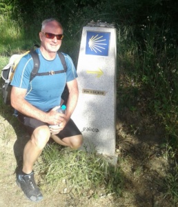 Kobus in front of a mile marker on the Camino de Santiago